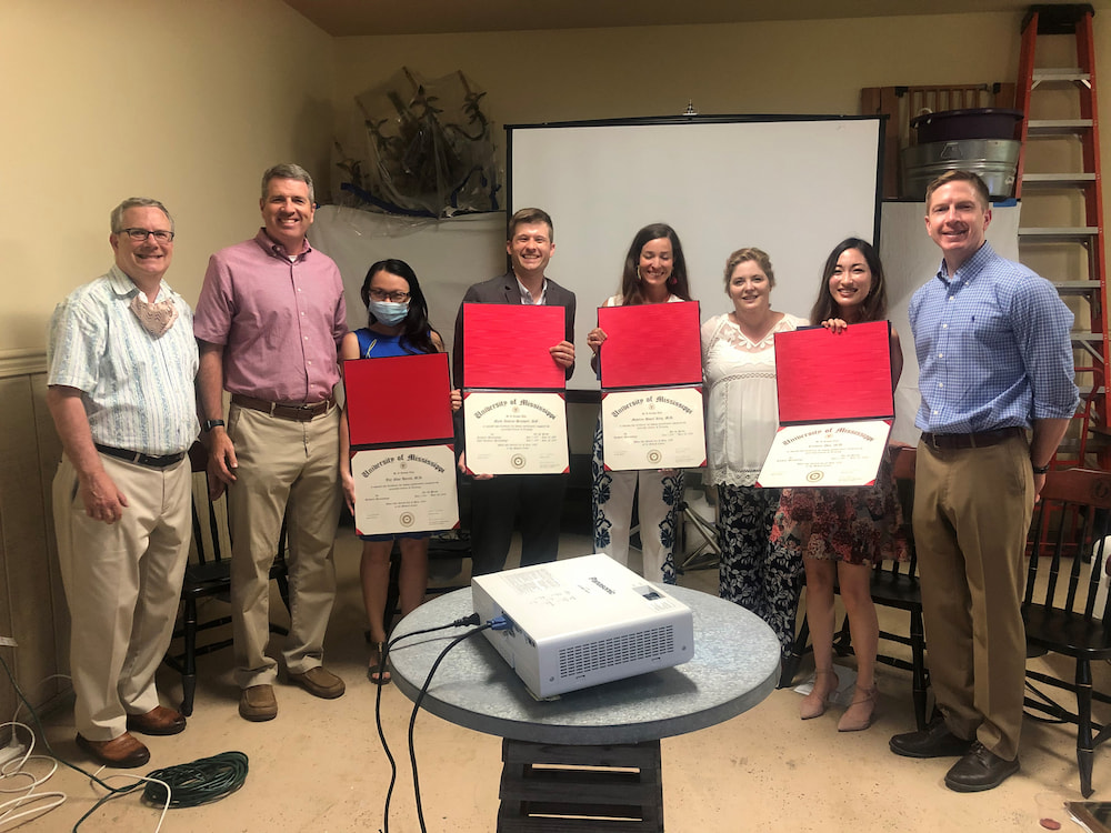 Faculty members Drs. Brodell, Jackson, McCowan, and Black present the graduating residents with their certificates.